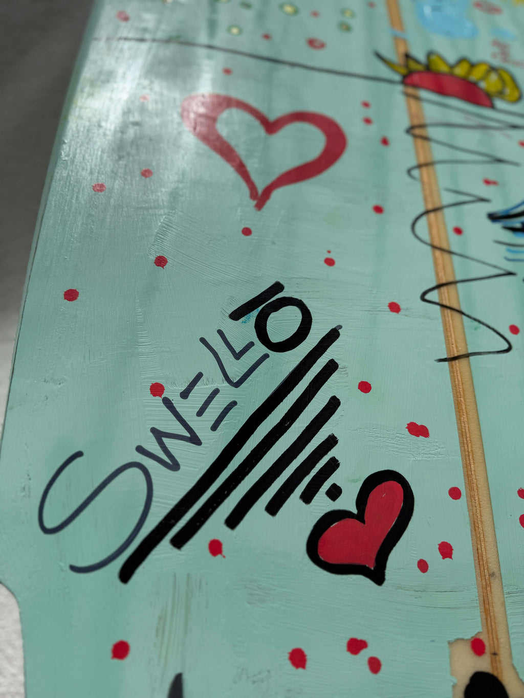 Close-up of the OG Wenzel MiniSimmons Surfboard by SWELLŌ showcasing the unique hand-painted design.